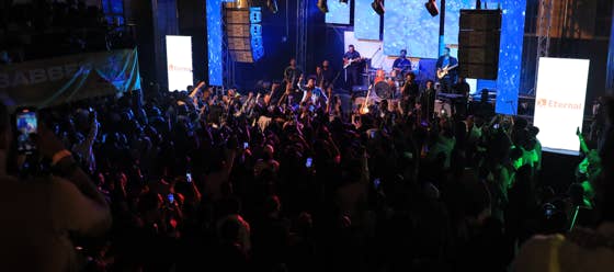 A crowded Zeruabbel Molla's concert with a stage lit by colorful lights and a large audience.