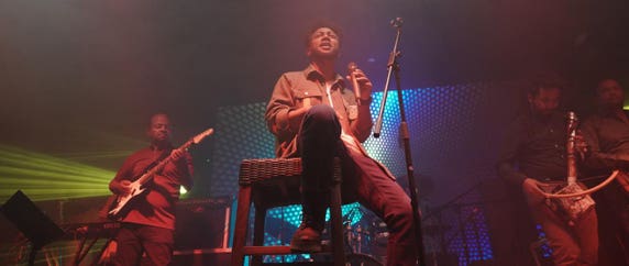 Zeruabbel Molla and his band performing on stage with colorful lighting effects.